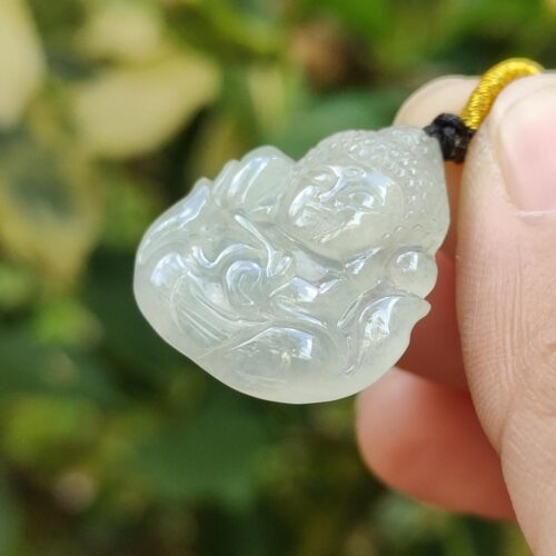 une main tenant un pendentif en jade