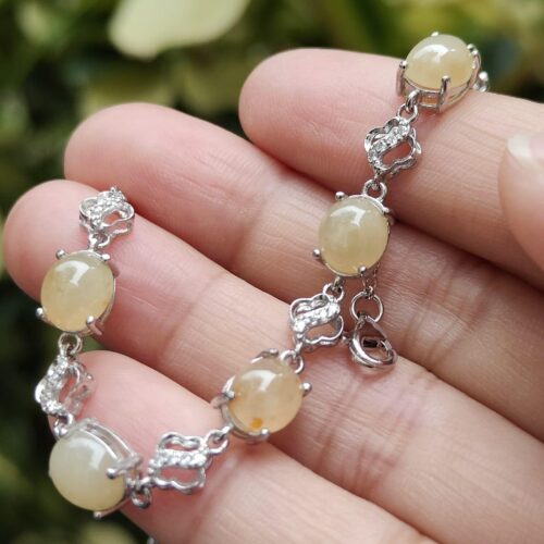 a hand holding a bracelet and earrings