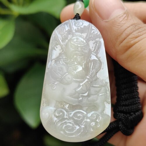 Una mano sosteniendo un colgante de jade.