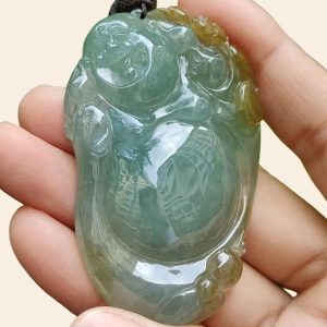 a hand holding a jade pendant