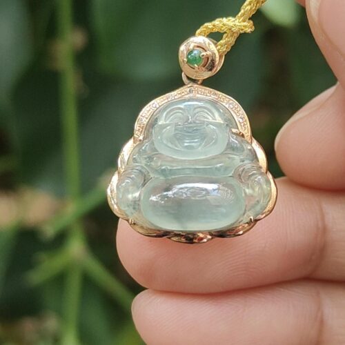 a hand holding a jade pendant