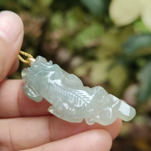 Una mano sosteniendo un colgante de jade.