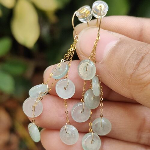 a hand holding a pair of earrings