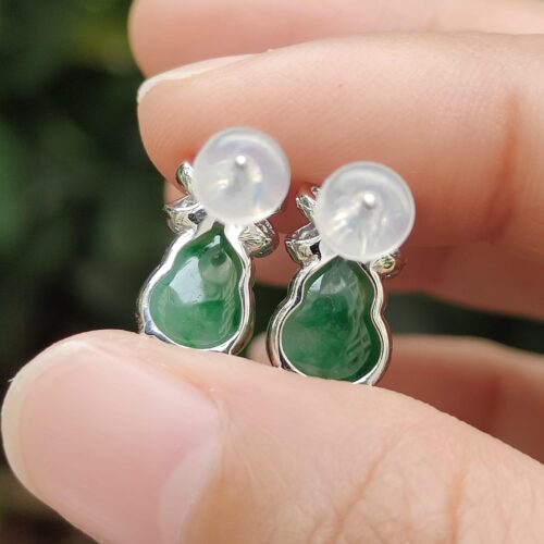 a hand holding a pair of earrings