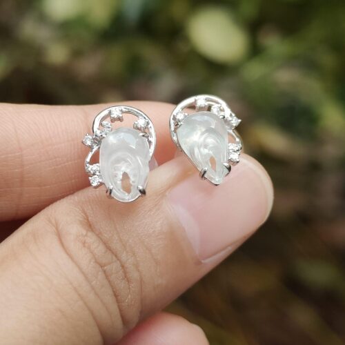 ஒரு ஜோடி காதணிகளை வைத்திருக்கும் நபர்