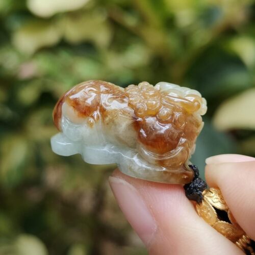 uma mão segurando um pequeno objeto de pedra