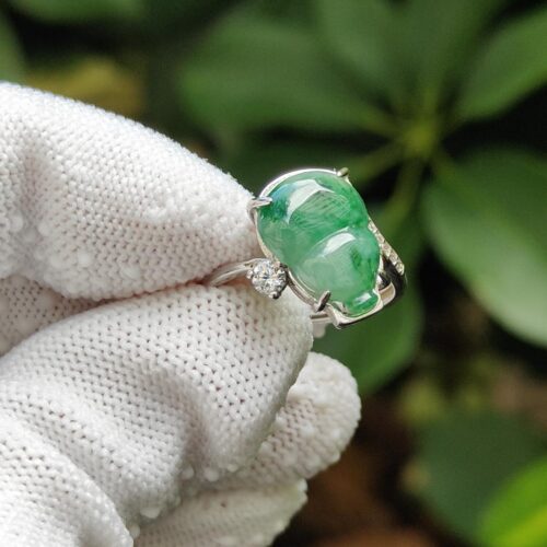 a hand wearing a gloved hand holding a ring