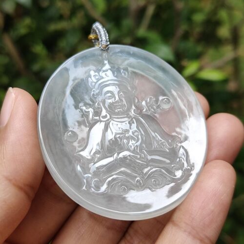 a hand holding a round white pendant