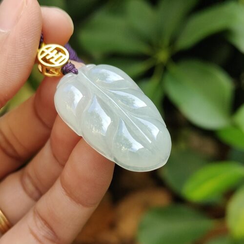 翡翠のペンダントを持つ手