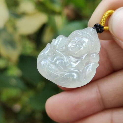 une main tenant un pendentif en jade