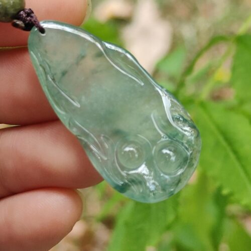 a hand holding a green necklace