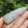 a hand holding a jade pendant