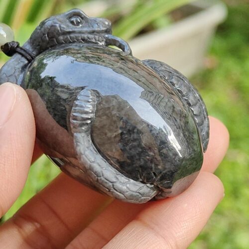 a hand holding a stone turtle