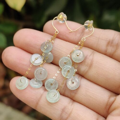 a hand holding a pair of earrings