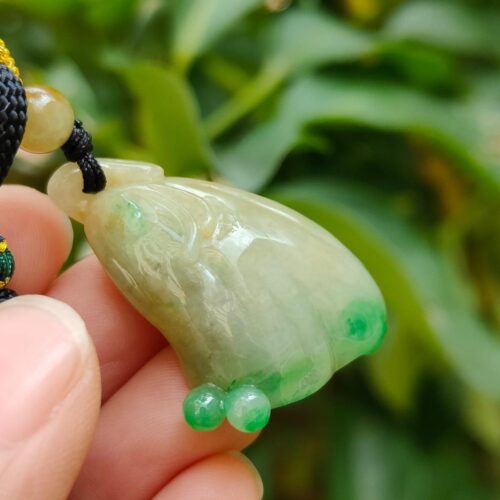 ஜேட் பதக்கத்தை வைத்திருக்கும் ஒரு கை