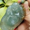 a hand holding a jade pendant