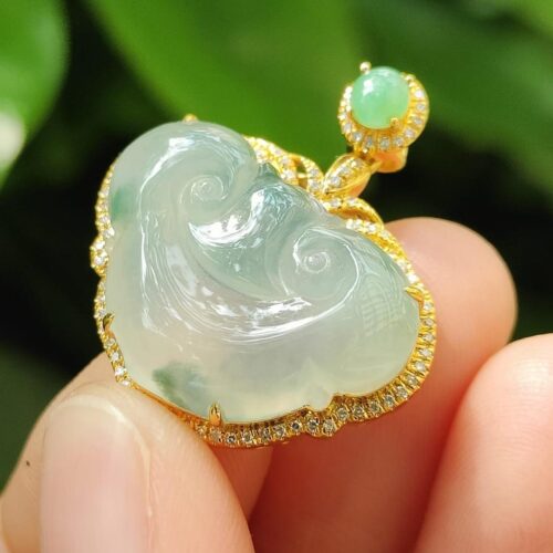 une main tenant un pendentif en jade