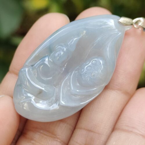 a hand holding a blue pendant