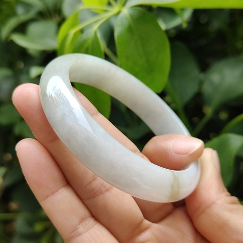 a hand holding a white bracelet