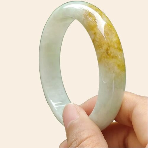 a hand holding a jade bracelet