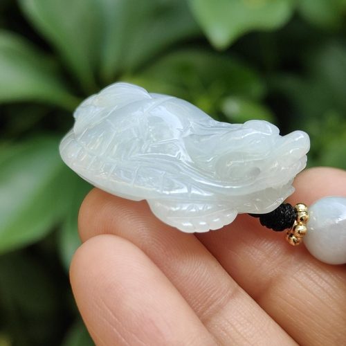 tangan memegang liontin giok