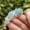 Una mano sosteniendo un colgante de jade.