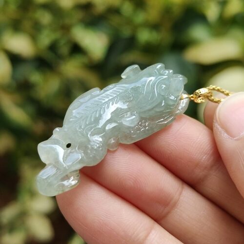 Una mano sosteniendo un colgante de jade.