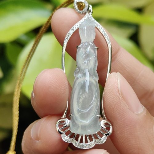 a hand holding a jade pendant