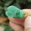 a hand holding a jade insect pendant