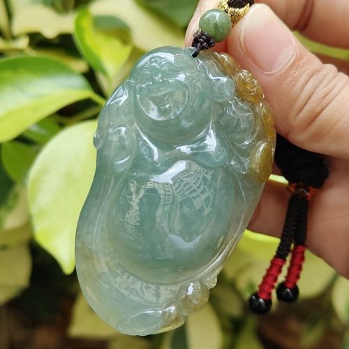 a hand holding a jade pendant
