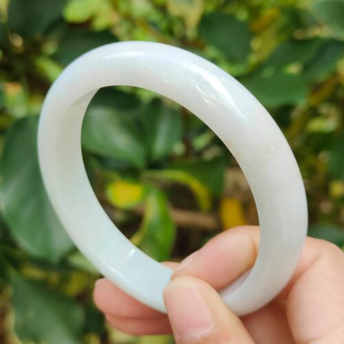 a hand holding a white bracelet