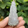 a hand holding a jade pendant