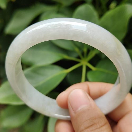 a hand holding a white bracelet