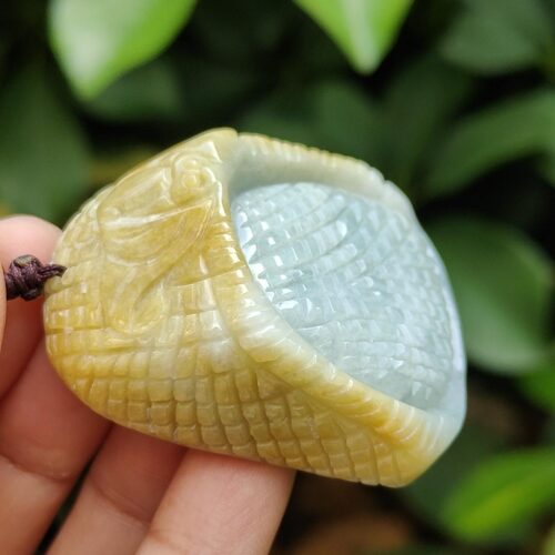 a hand holding a jade pendant