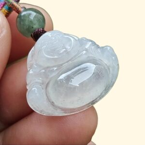 a hand holding a jade pendant