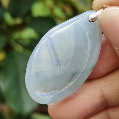 a hand holding a blue stone pendant