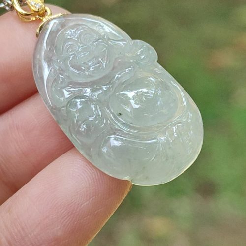 a hand holding a jade pendant