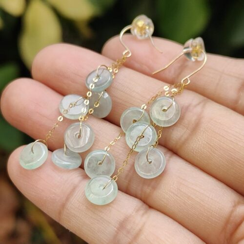 a hand holding a pair of earrings