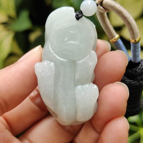 एक हाथ में जेड पेंडेंट थामे हुए