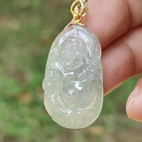 a hand holding a jade pendant