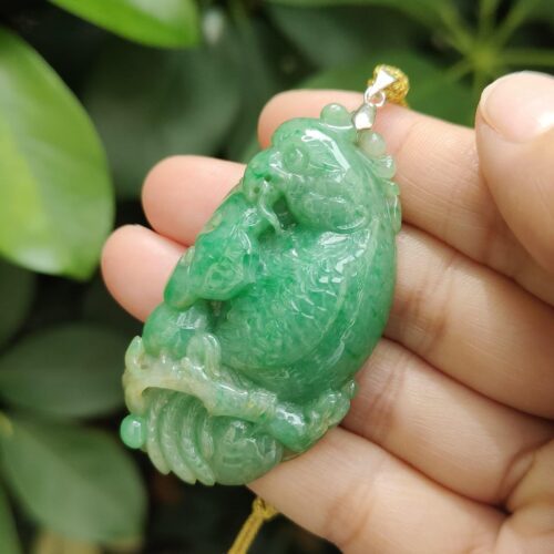 翡翠のペンダントを持つ手