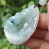 a hand holding a jade pendant
