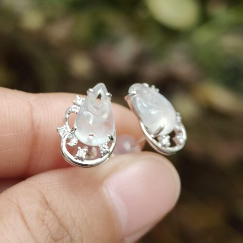 ஒரு ஜோடி காதணிகளை வைத்திருக்கும் நபர்