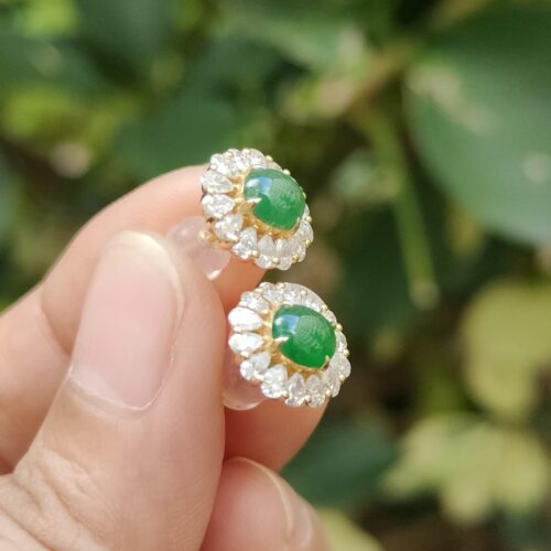 ஒரு ஜோடி காதணிகளை வைத்திருக்கும் ஒரு கை