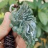 a hand holding a jade pendant