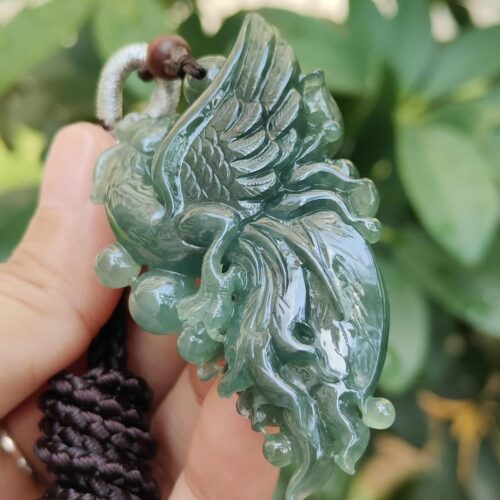a hand holding a jade pendant