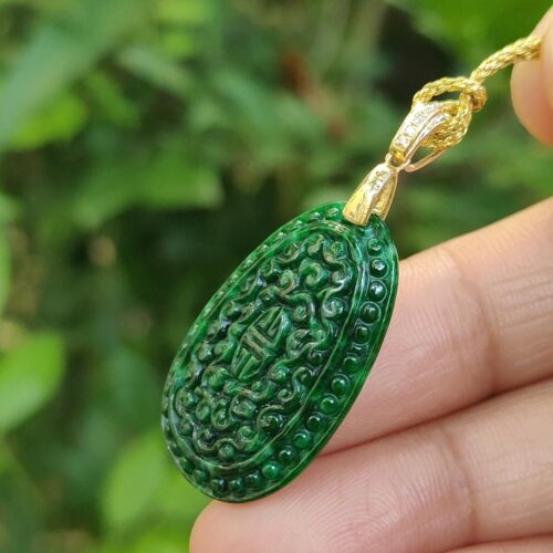 a hand holding a green pendant