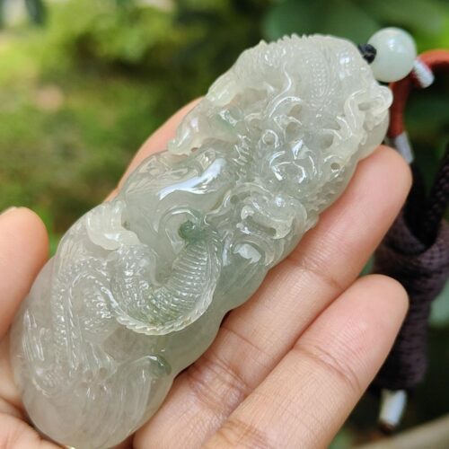 une main tenant un objet en jade