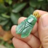 a hand holding a jade pendant