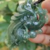 a hand holding a jade pendant